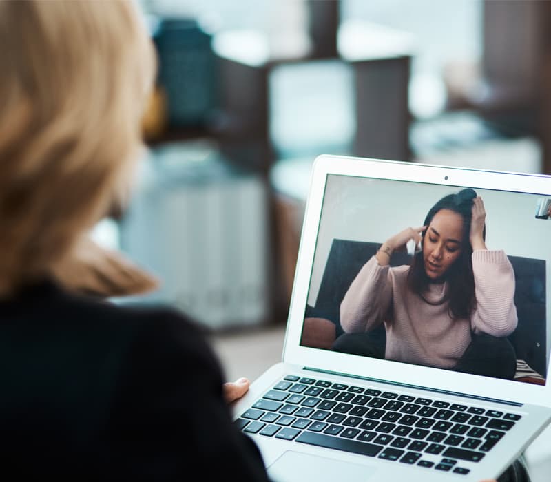 Doctora usando laptop para consulta virtual
